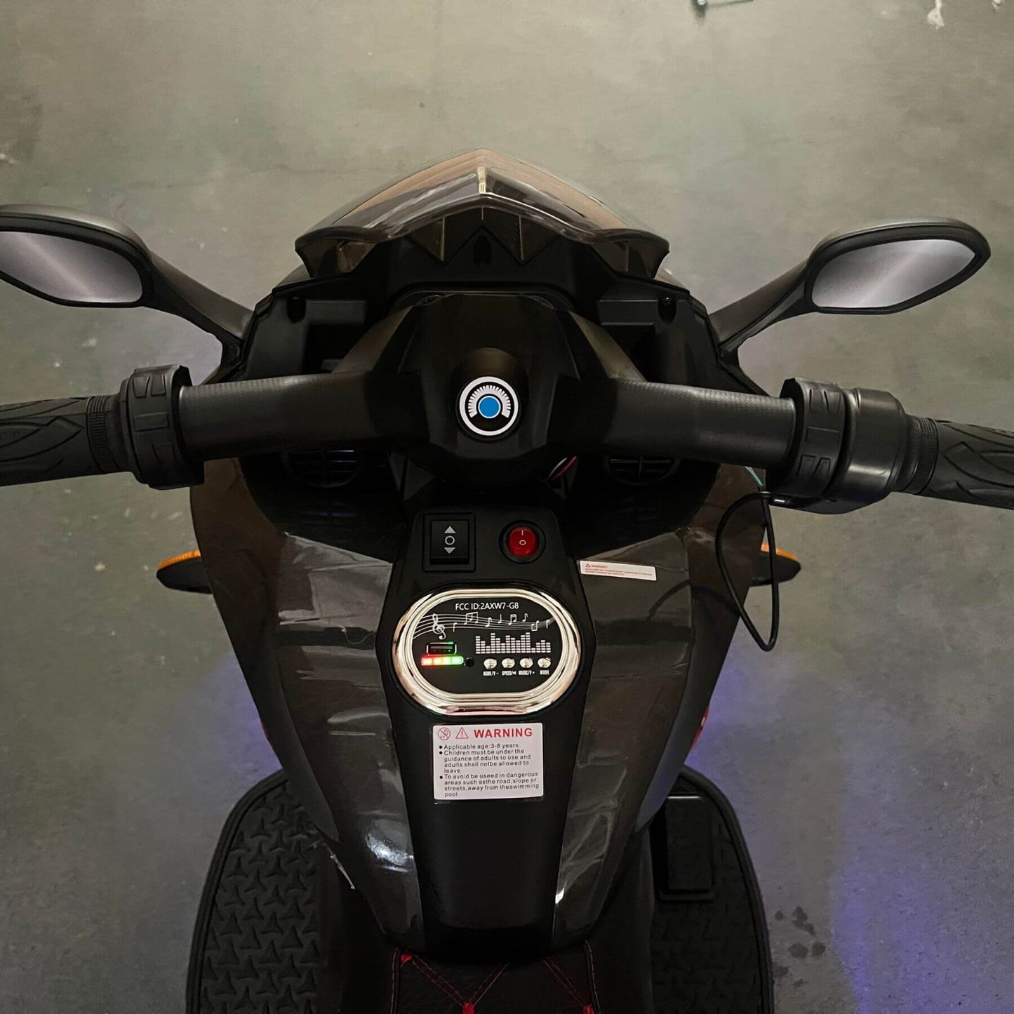 Close-up of a motorcycle's handlebar and dashboard on a gray background