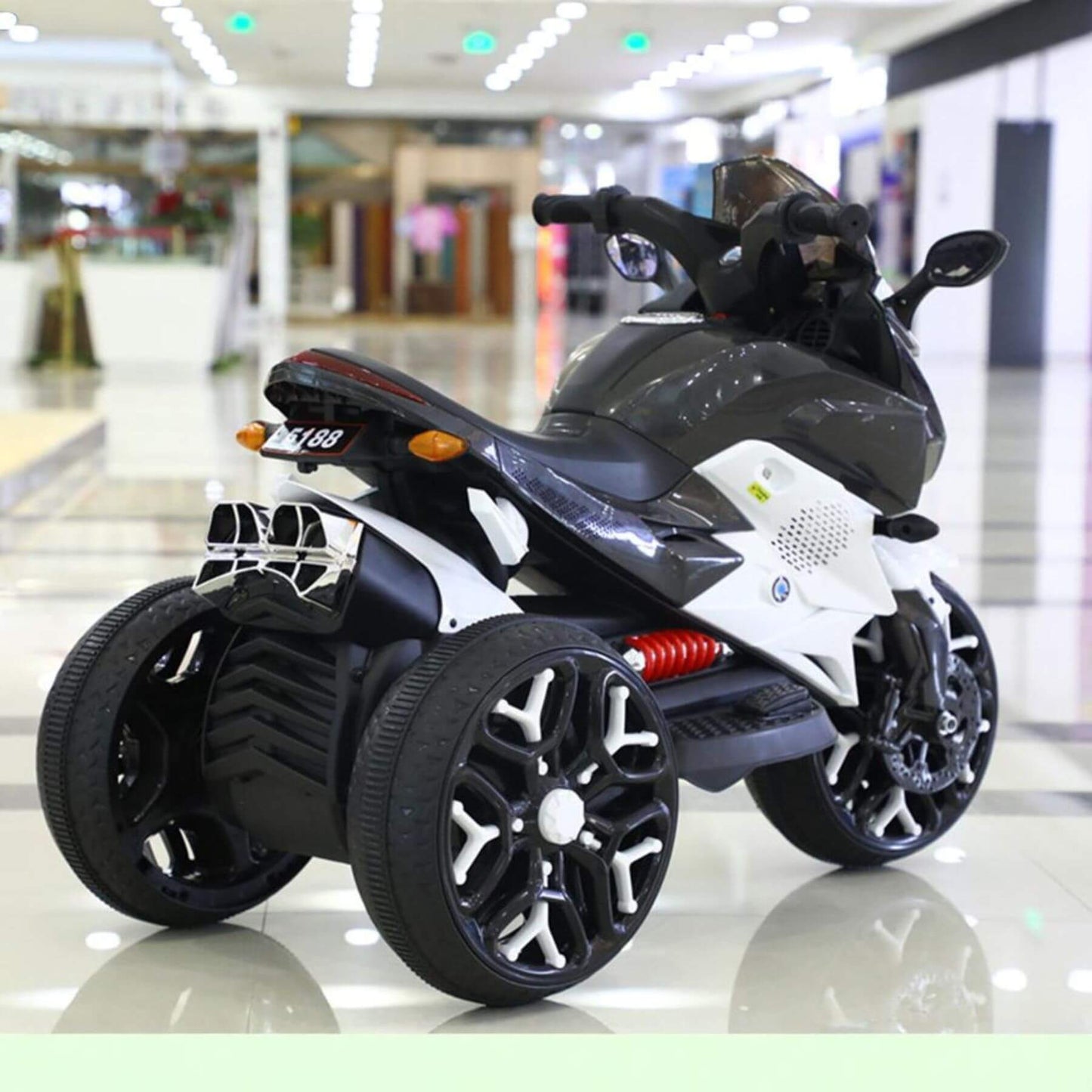 Tamco Kids Motorcycle Ride-On 3-Wheels Battery Powered Motorbike - White on a reflective floor with a blurred indoor background