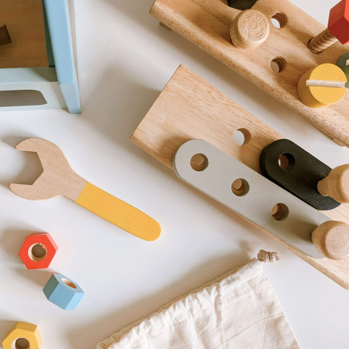 Wooden toy tools and blocks on a white surface
