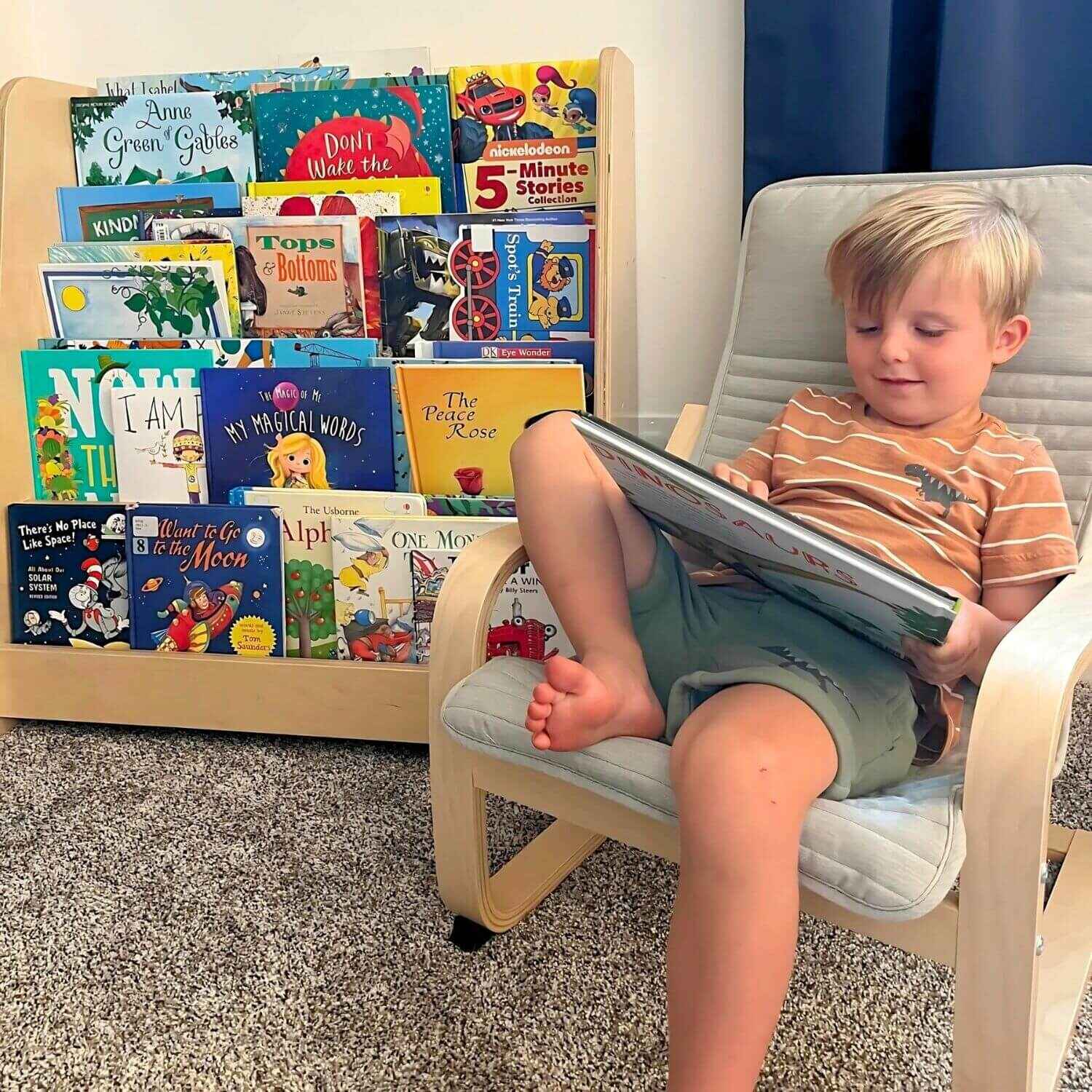 Boy Reading next to RAD Children's Furniture Tiered Montessori Bookshelf