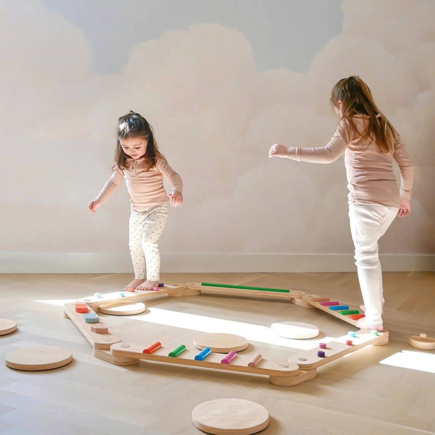 Two children playing with Tiny Land® Balance Beam indoors.