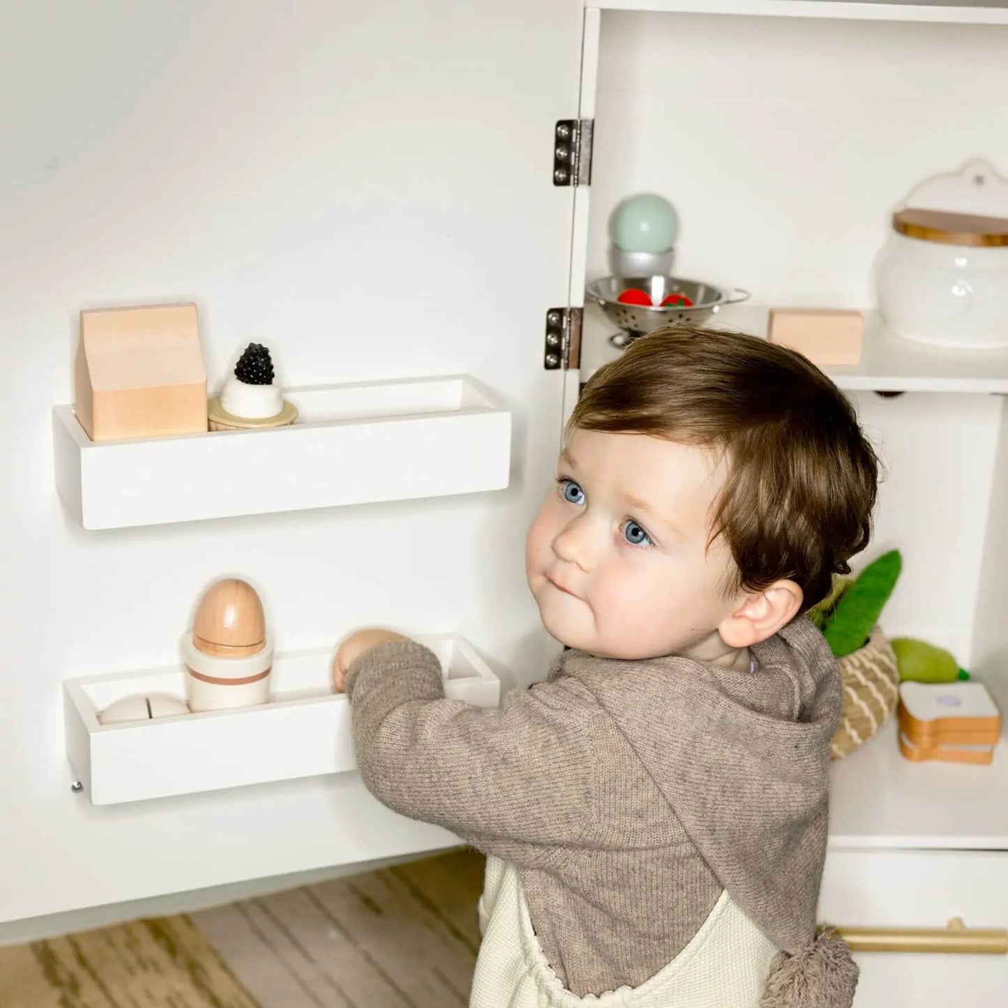 Child playing with Tiny Land® Cabinet Play Fridge.