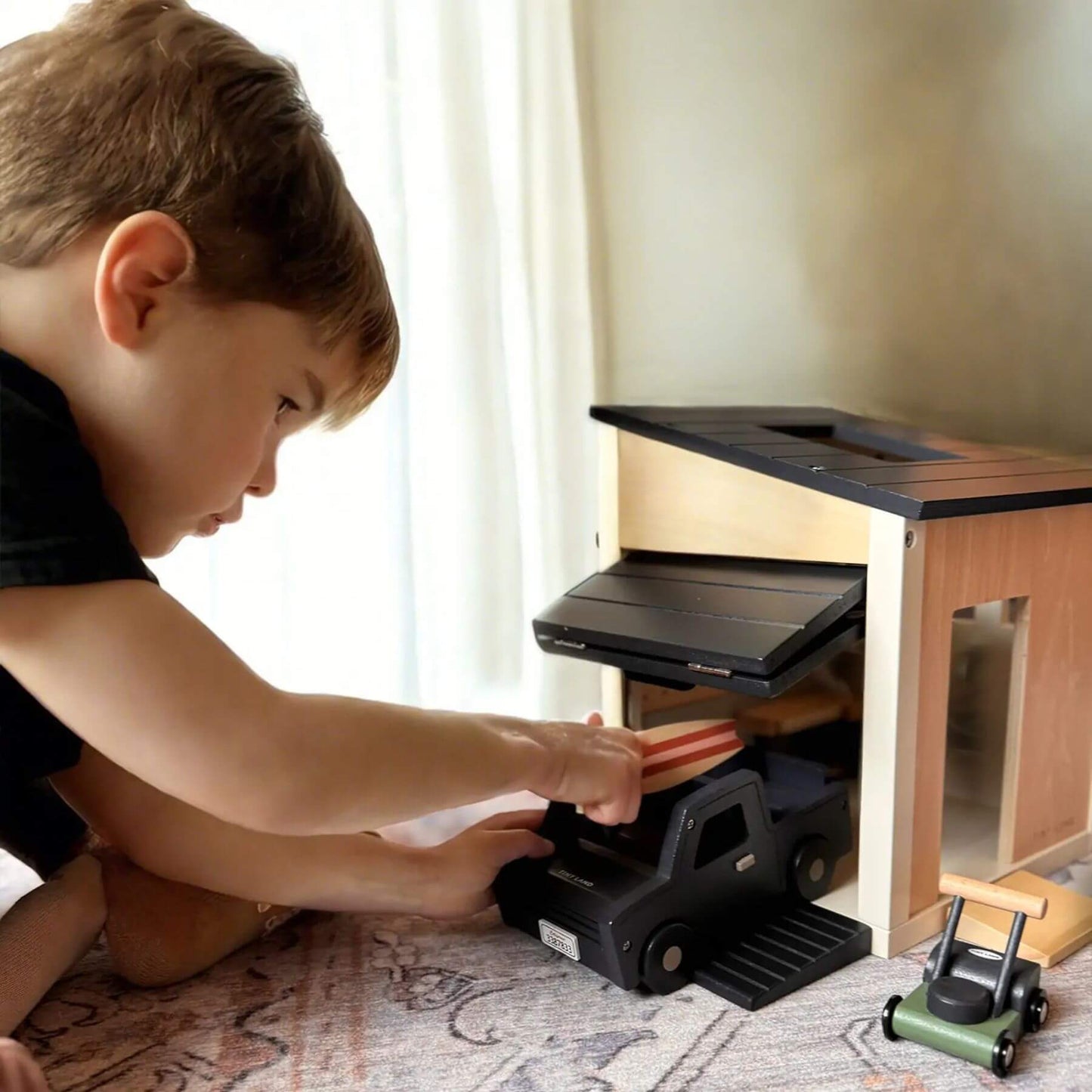 Boy Playing Tiny Land® Wooden Dollhouse - Garage
