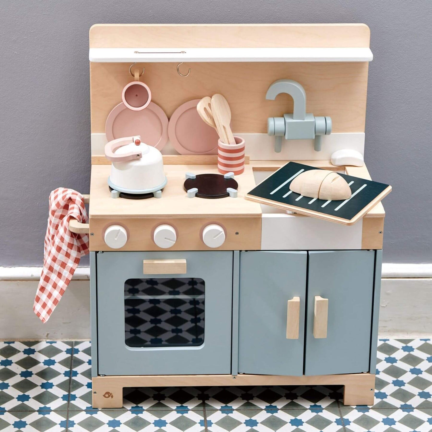 Tender Leaf Home Kitchen with toy utensils and appliances on a gray wall background.