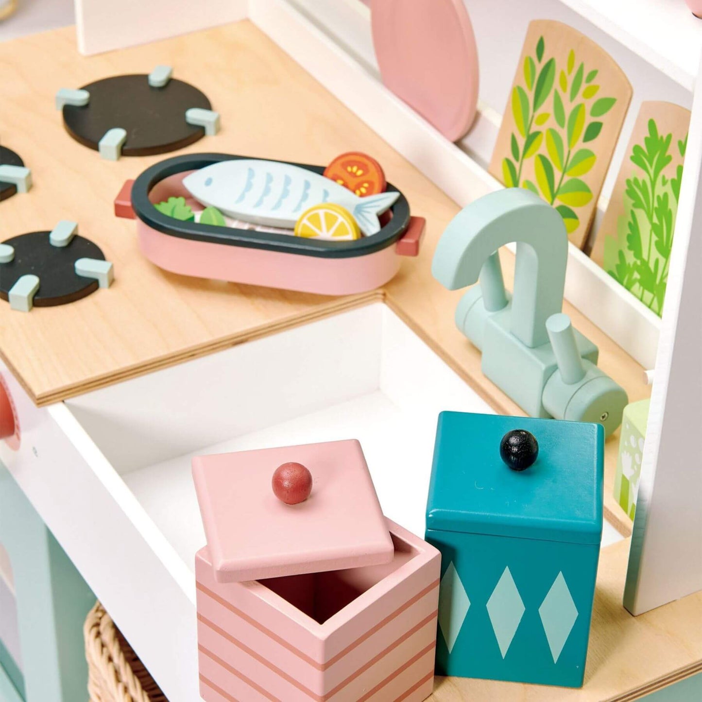 Children's toy kitchen set with wooden counter, pink and blue containers, and food items.