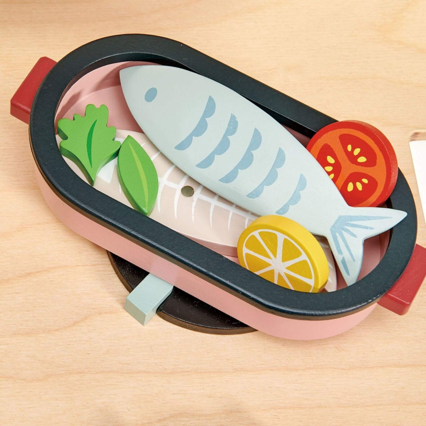Toy sushi set with fish, vegetables, and lemon on a wooden surface