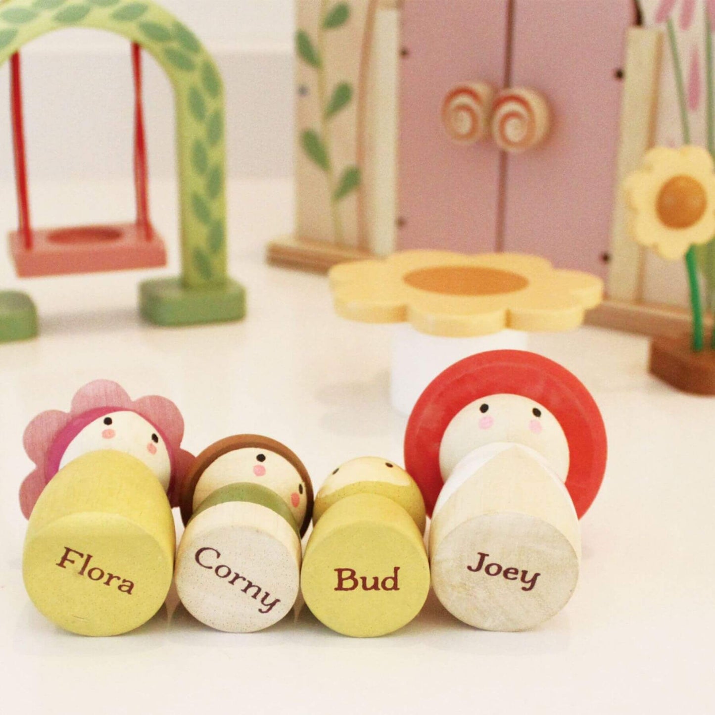 Set of wooden toy figures with names on a white surface