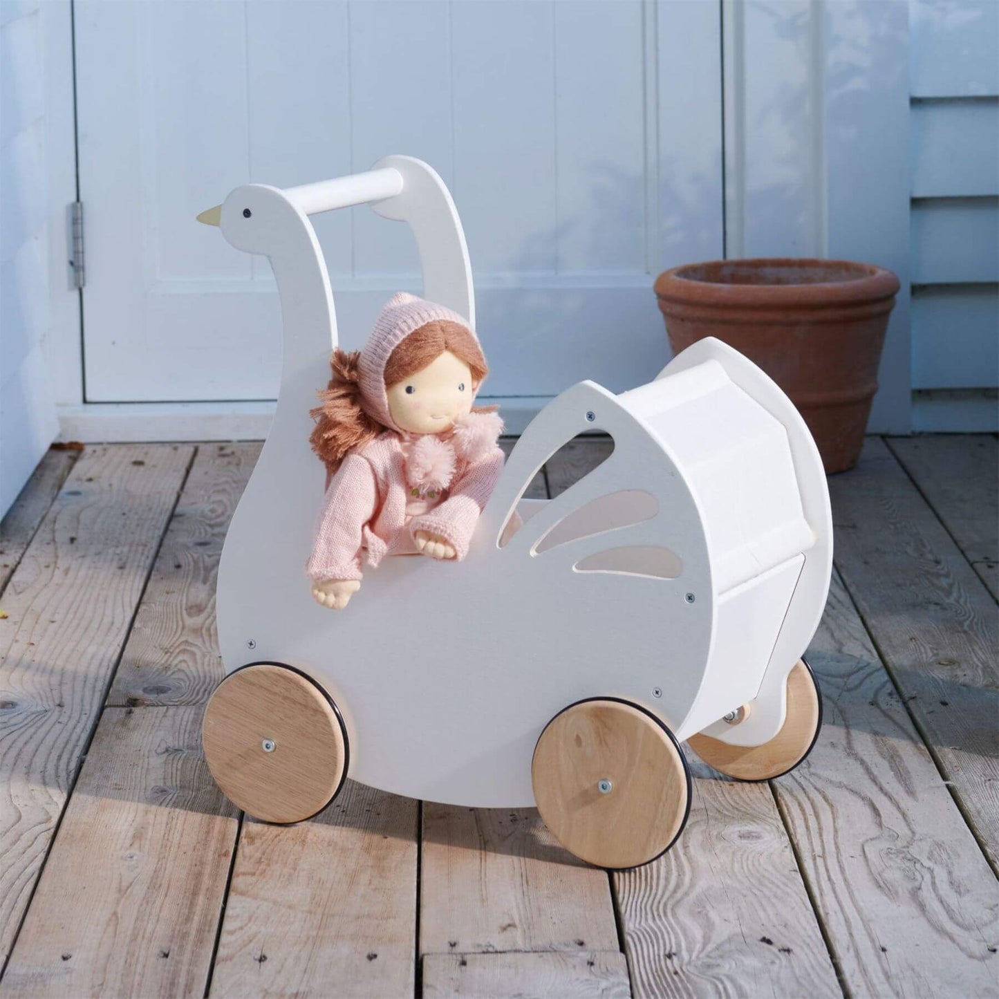 Tender Leaf Sweet Swan Pram with a doll on a wooden floor