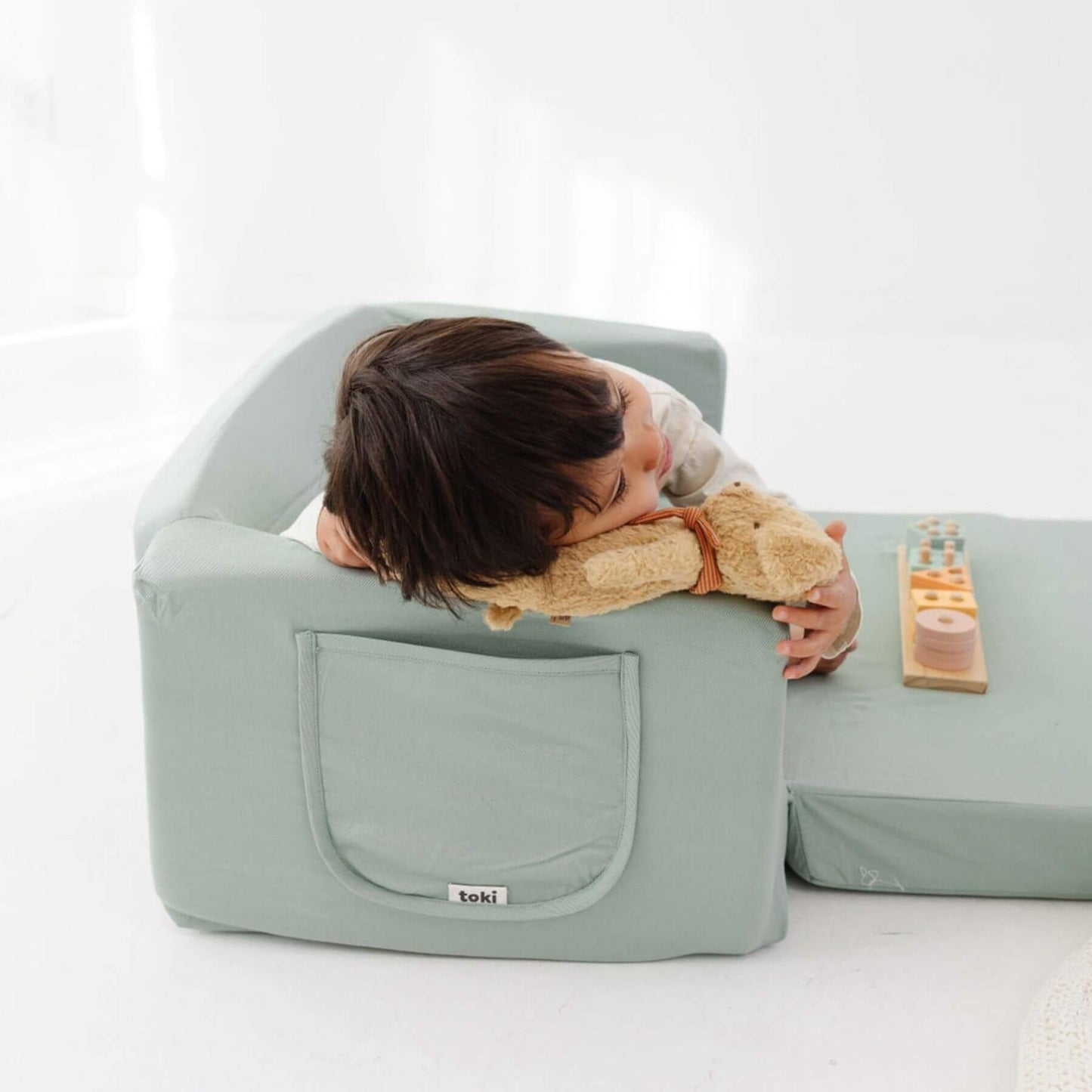 Child lying on Toki Kids Sage Play Couch
