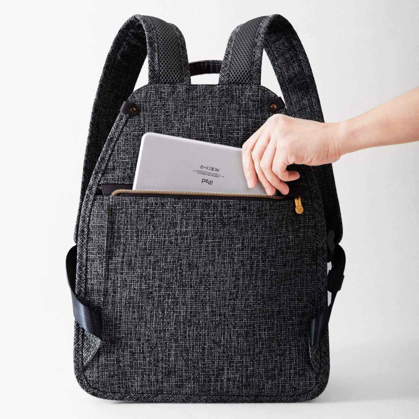 Person placing a tablet into Sunveno Tweed Luxe Diaper Bag Backpack - Black