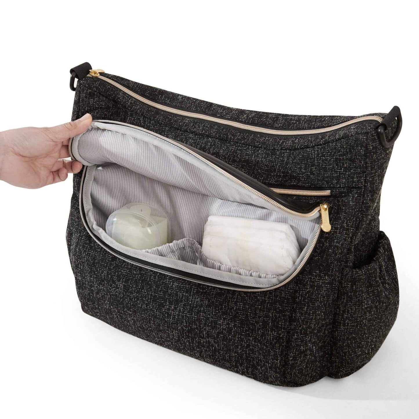 Tweed Luxe Stroller Organizer Black with a hand opening it to reveal white items inside on a white background
