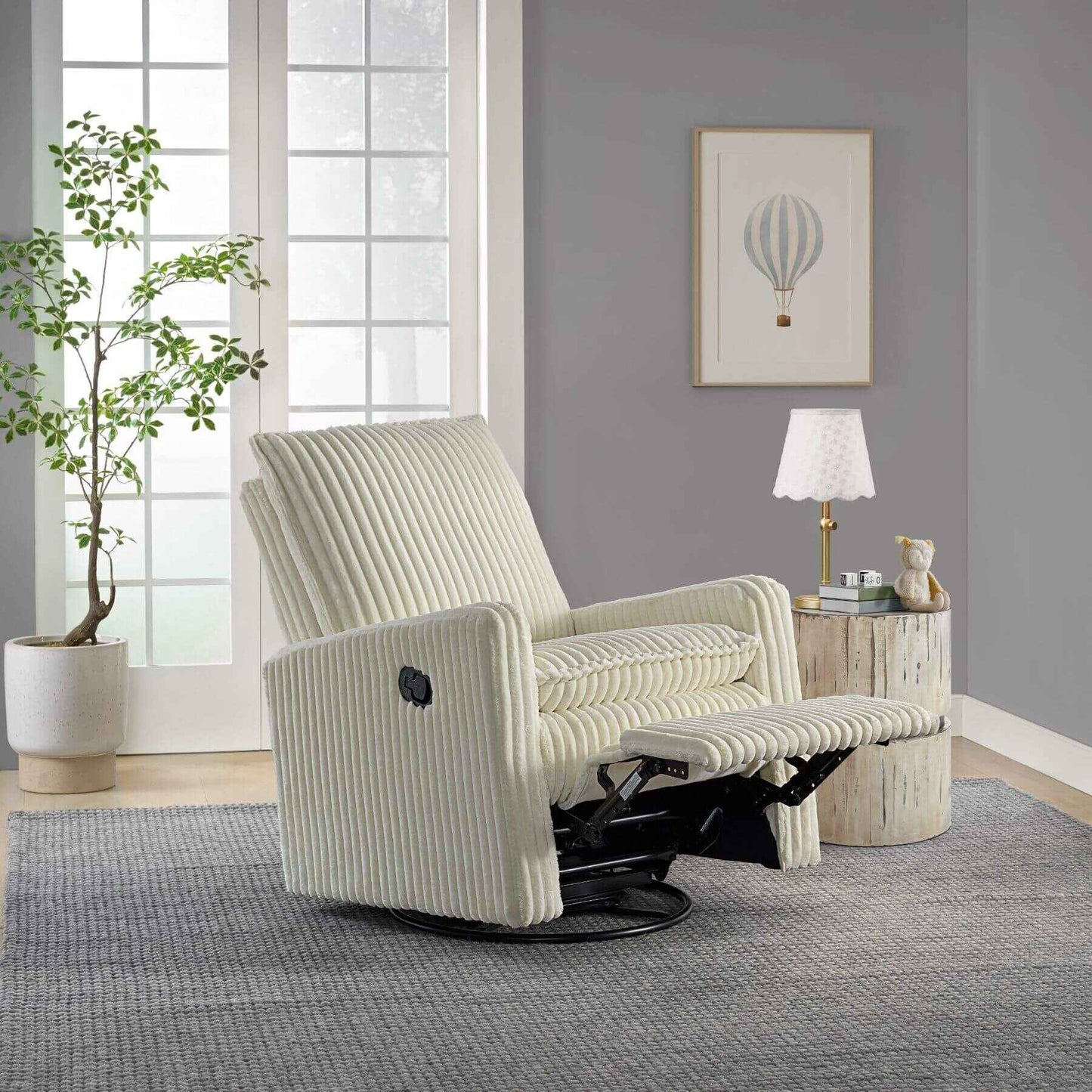 Uptown Nursery Swivel Rocker and Recliner in Corduroy Pearl White in a living room setting with a plant, lamp, and artwork on the wall.