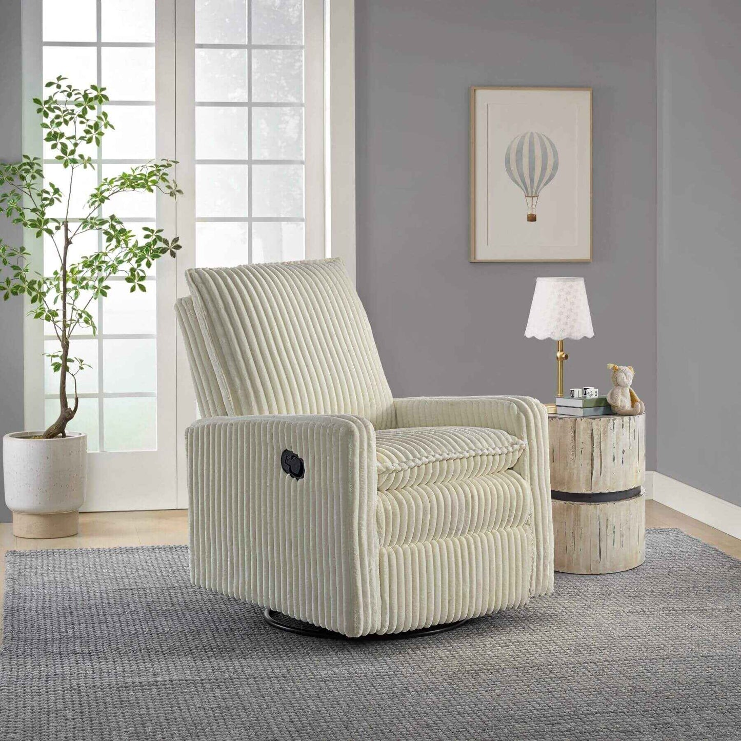 Uptown Nursery Swivel Rocker and Recliner in Corduroy Pearl White in a living room setting with a plant and side table.