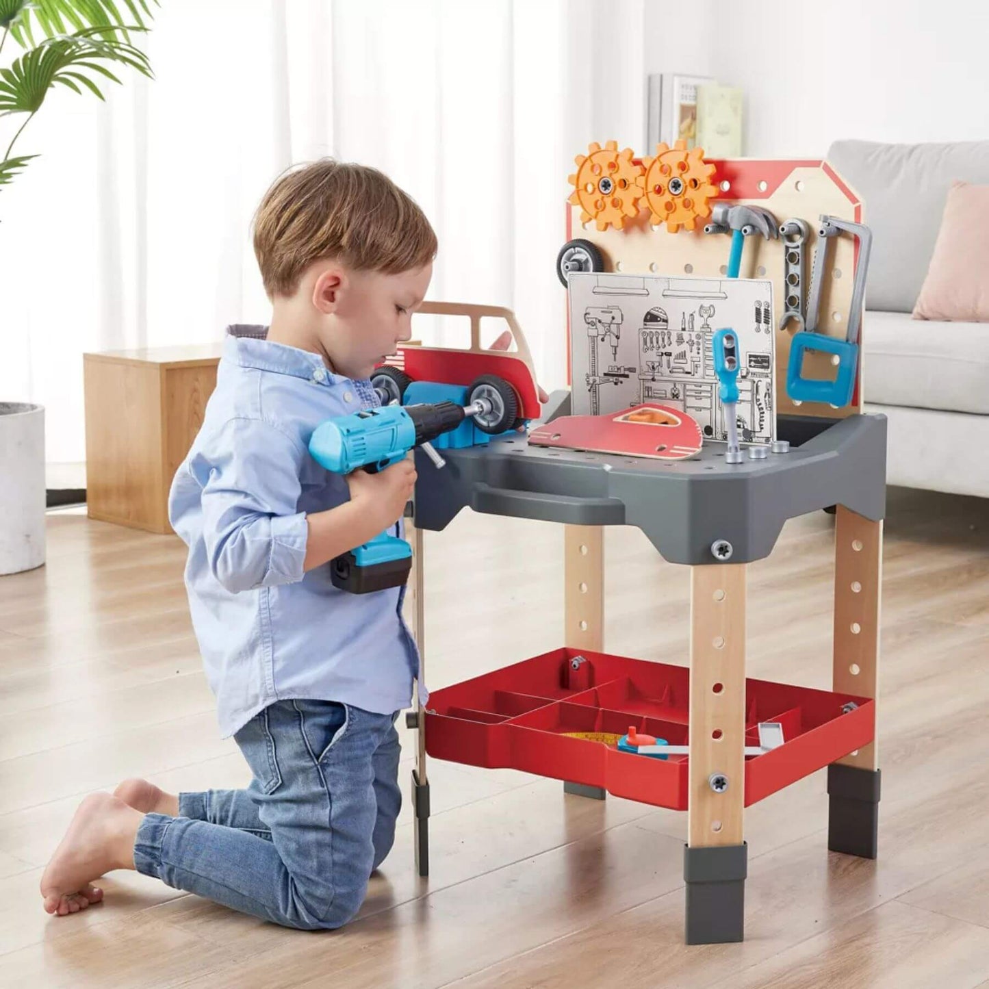 Child playing with Hape Vehicle Service & Repair Workbench in a living room.