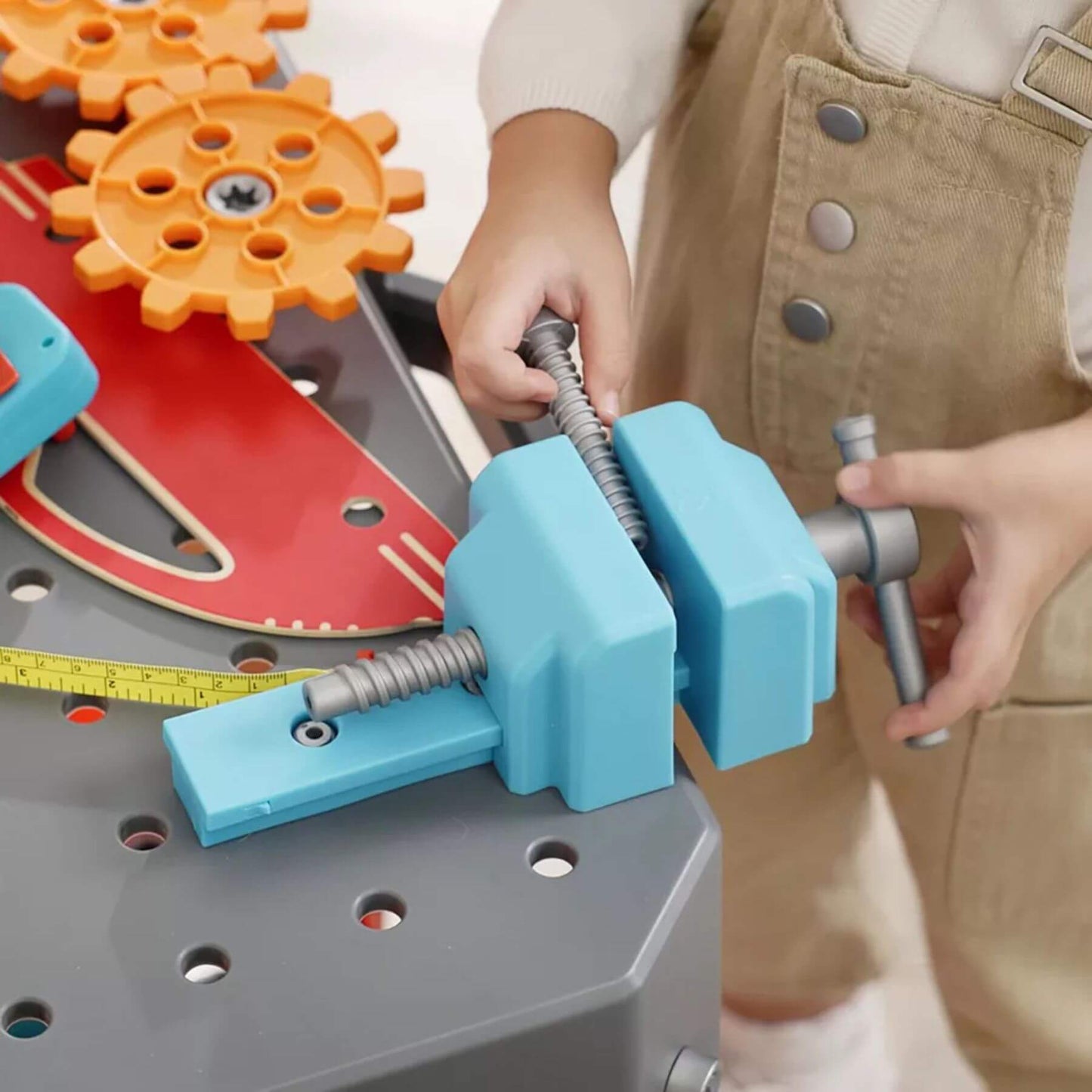 Child playing with Hape Vehicle Service & Repair Workbench