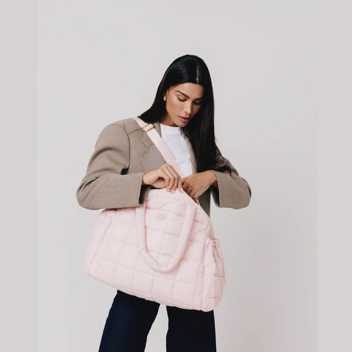 Woman holding augustnoa the weekender duffle bag pink