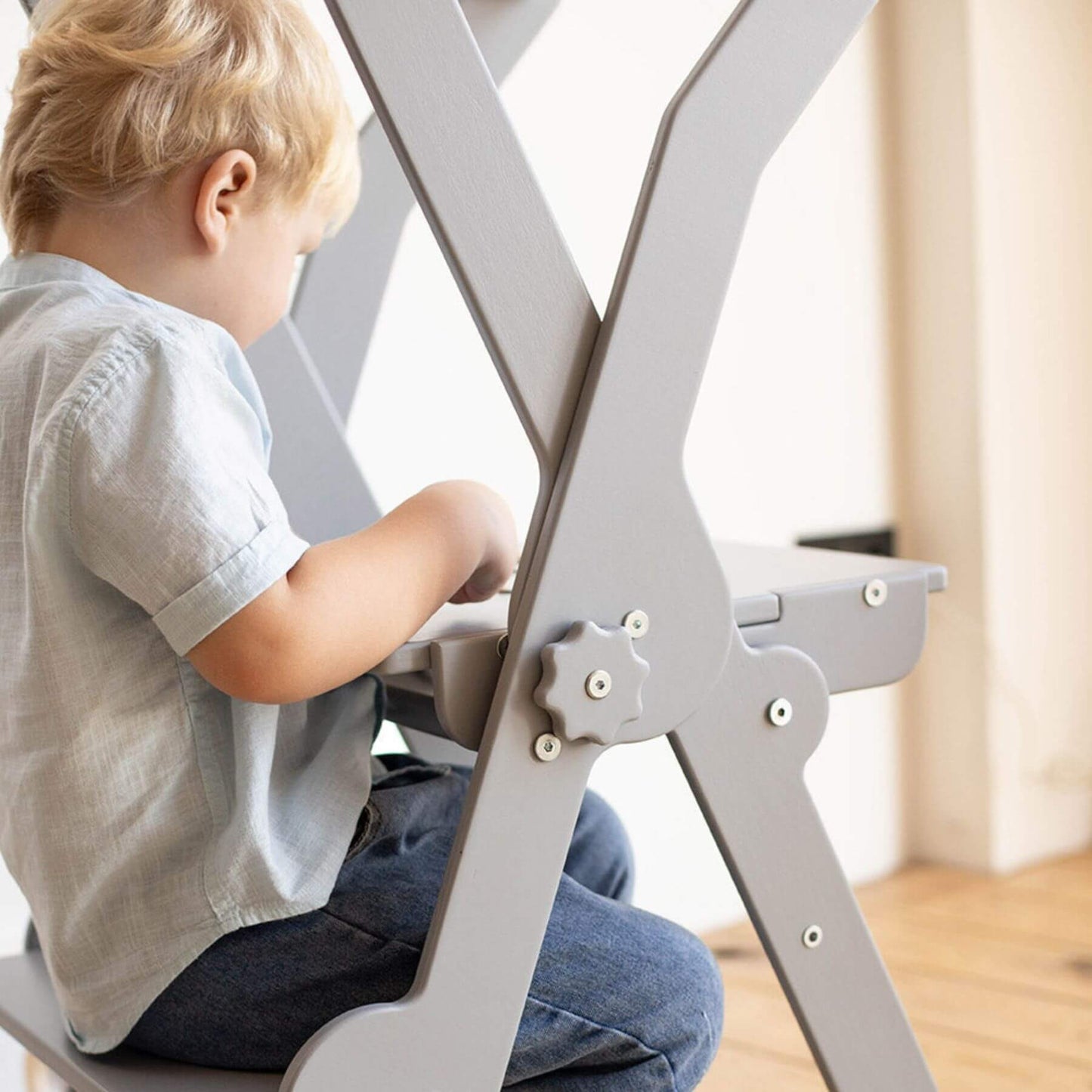 Boy Sitting at Wood and Hearts Foldable Kitchen Tower in Gray