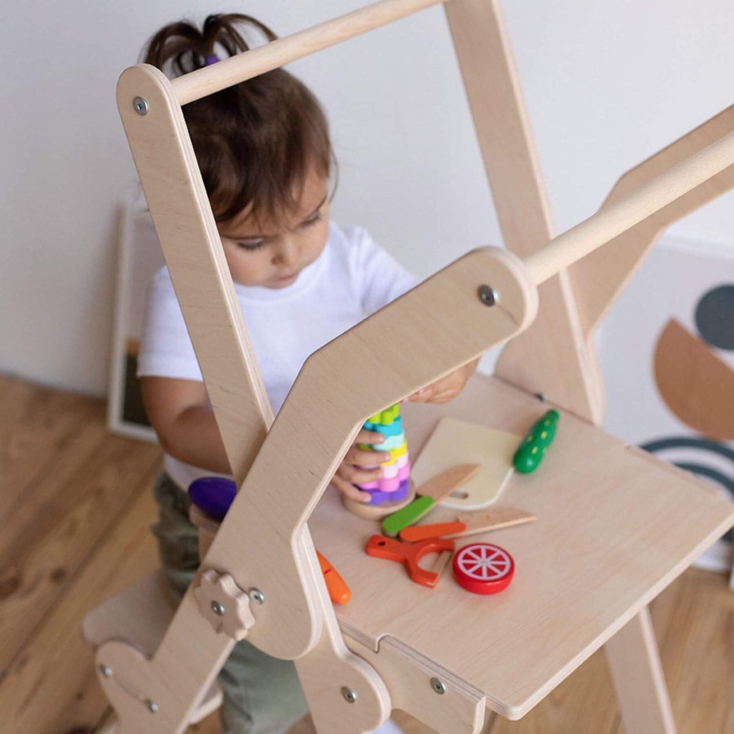 Girl Playing Toys, Sitting on Wood and Hearts Foldable Kitchen Tower in Natural Wood