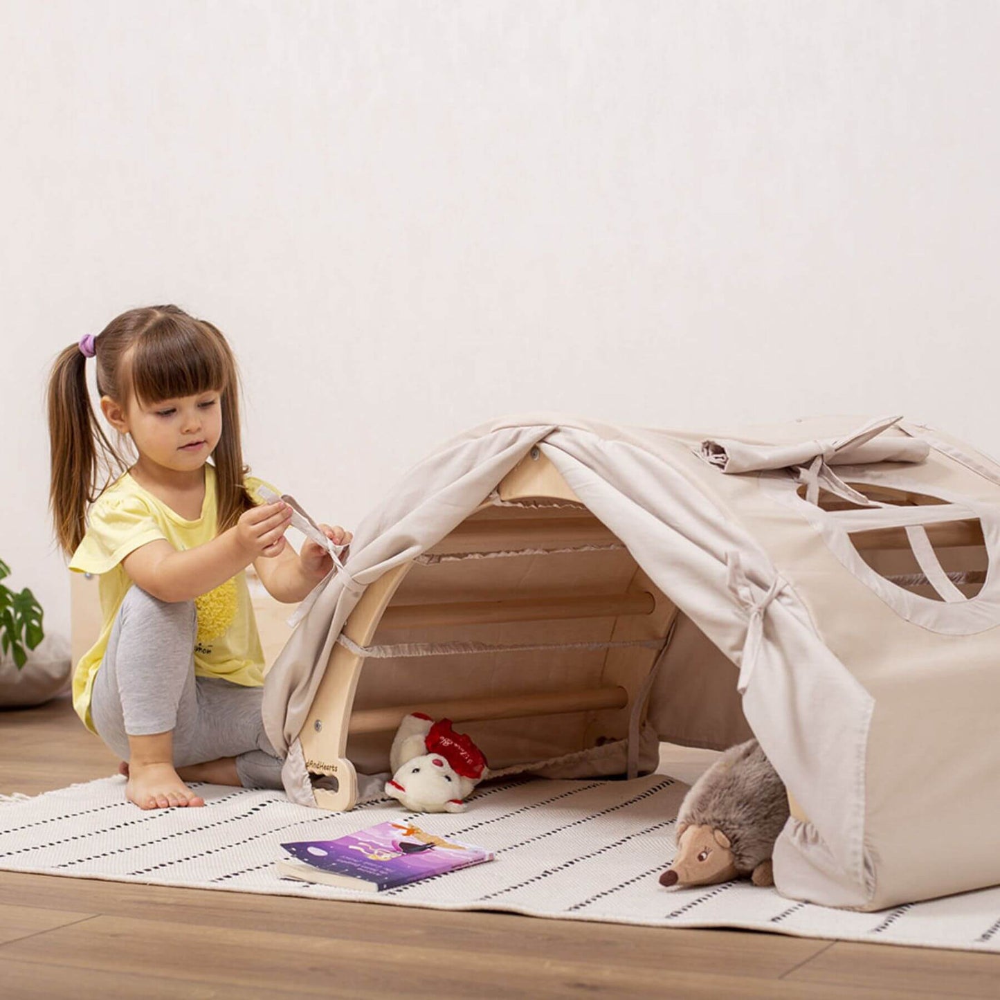 Girl Ties Tent to Wood and Hearts Large Climbing Arch Sandy Bay