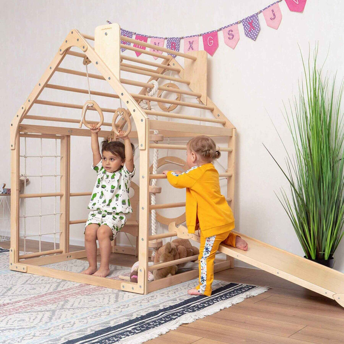 Girl Playing on Wood and Hearts Wooden Climbing Playhouse w/ Ramp, 3 Ropes