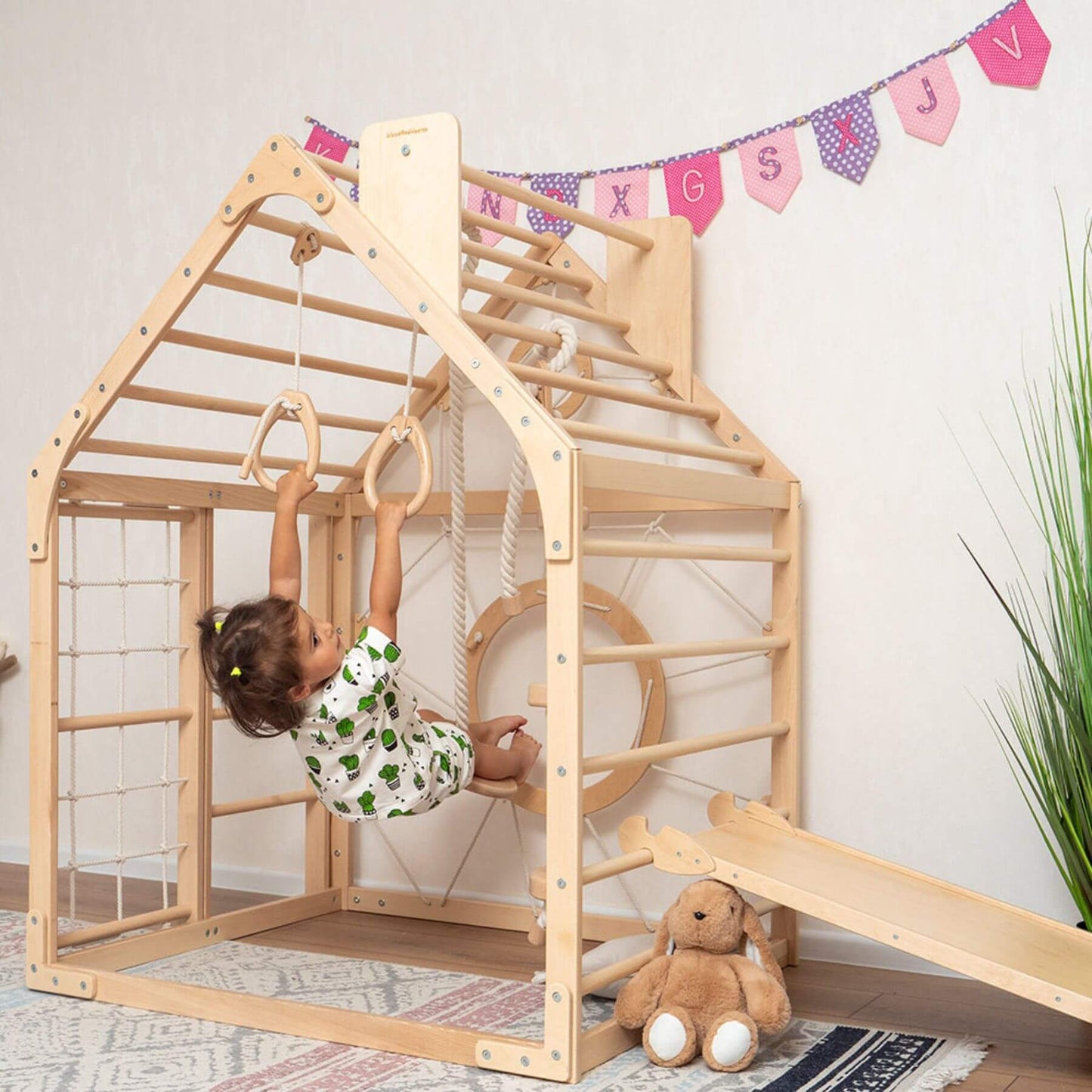 Girl Playing on Wood and Hearts Wooden Climbing Playhouse w/ Ramp, 3 Ropes