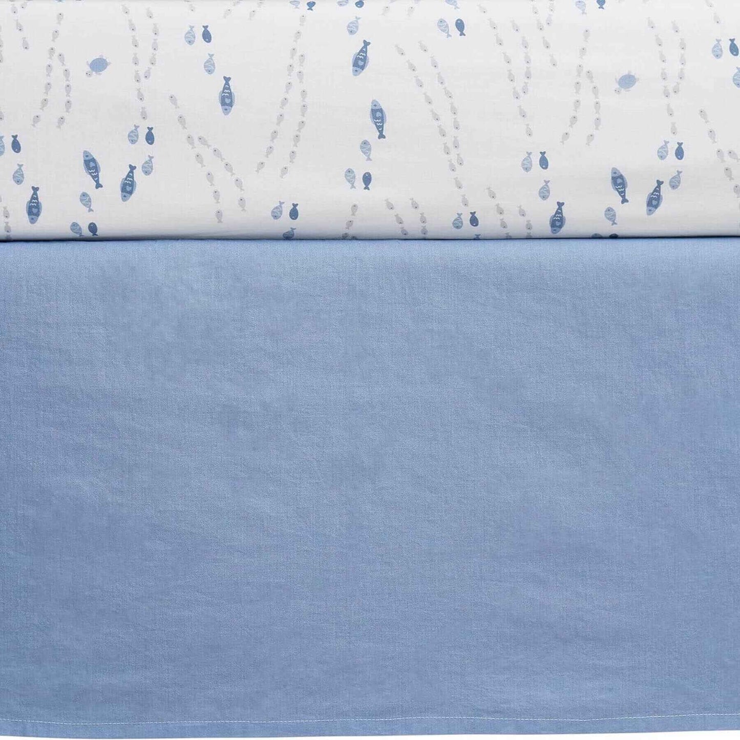 Close-up of a quilt with blue fish pattern on a white background