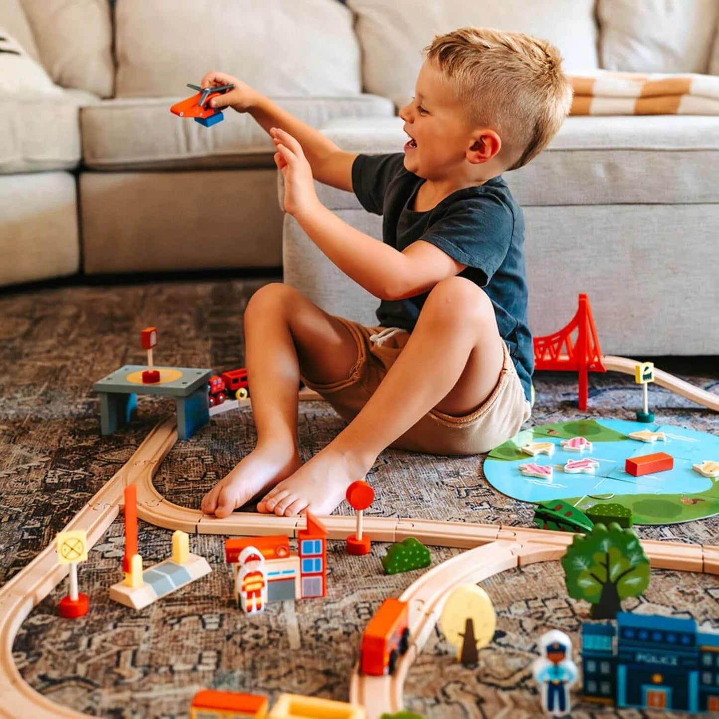 Boy Playing Tiny Land® Wooden Train Set 110 Pcs