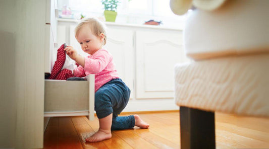 Baby pulling cloth from drawer