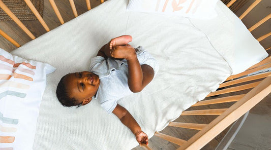 boy sleeping on crib mattress