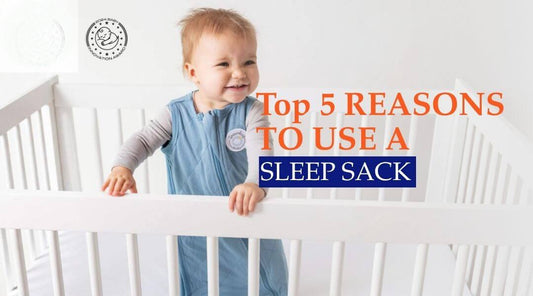 baby in blue sleep sack standing in a crib