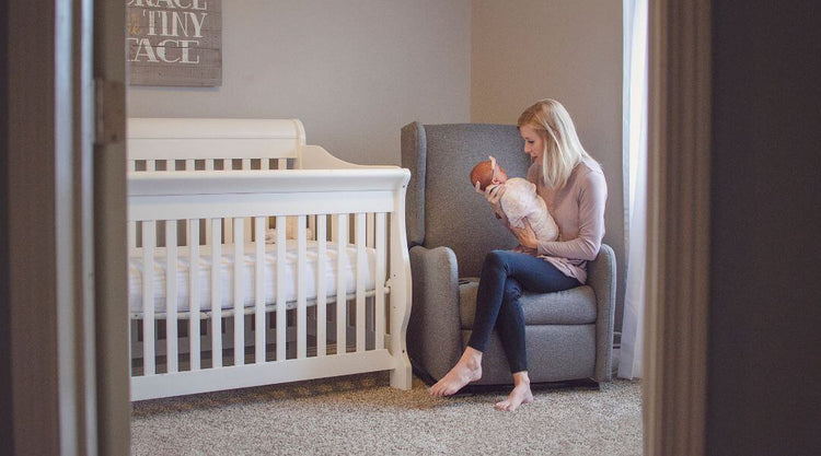 mom holding baby in nursery room