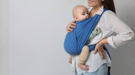 mom holding a baby with a blue carrier