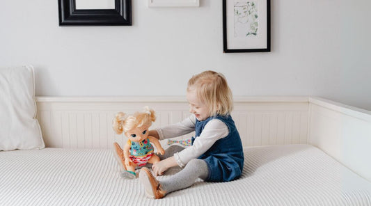 Girl Sitting on Toddler Bed