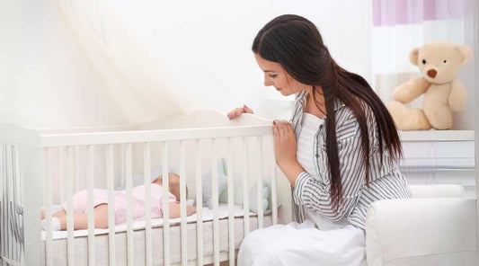 Mom watching baby in crib