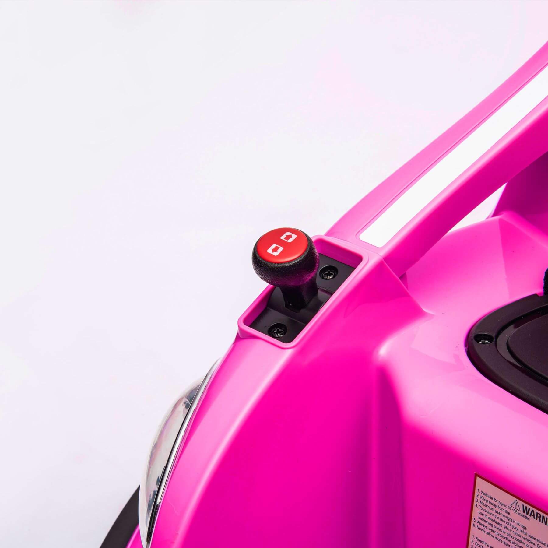 Close-up of a pink toy car with a red button on a white background