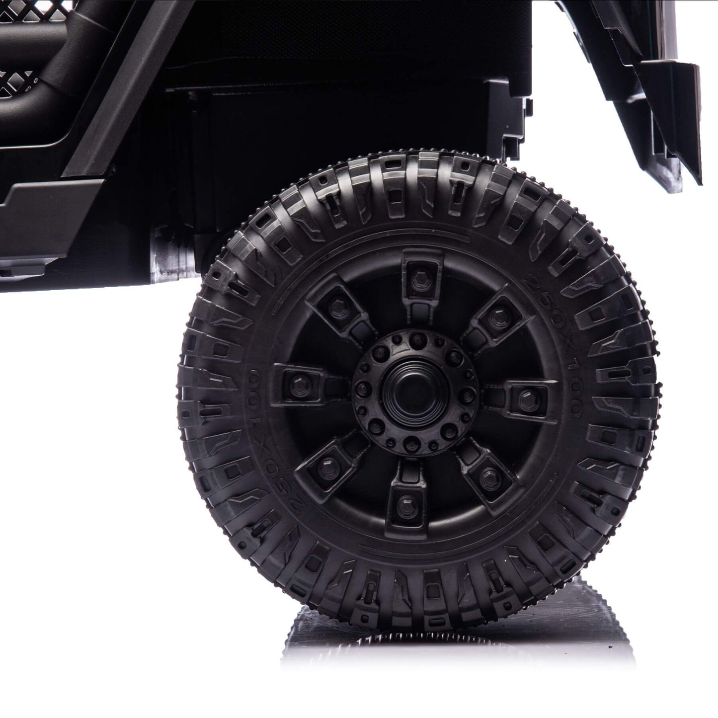 Close-up of a black off-road vehicle tire on a white background