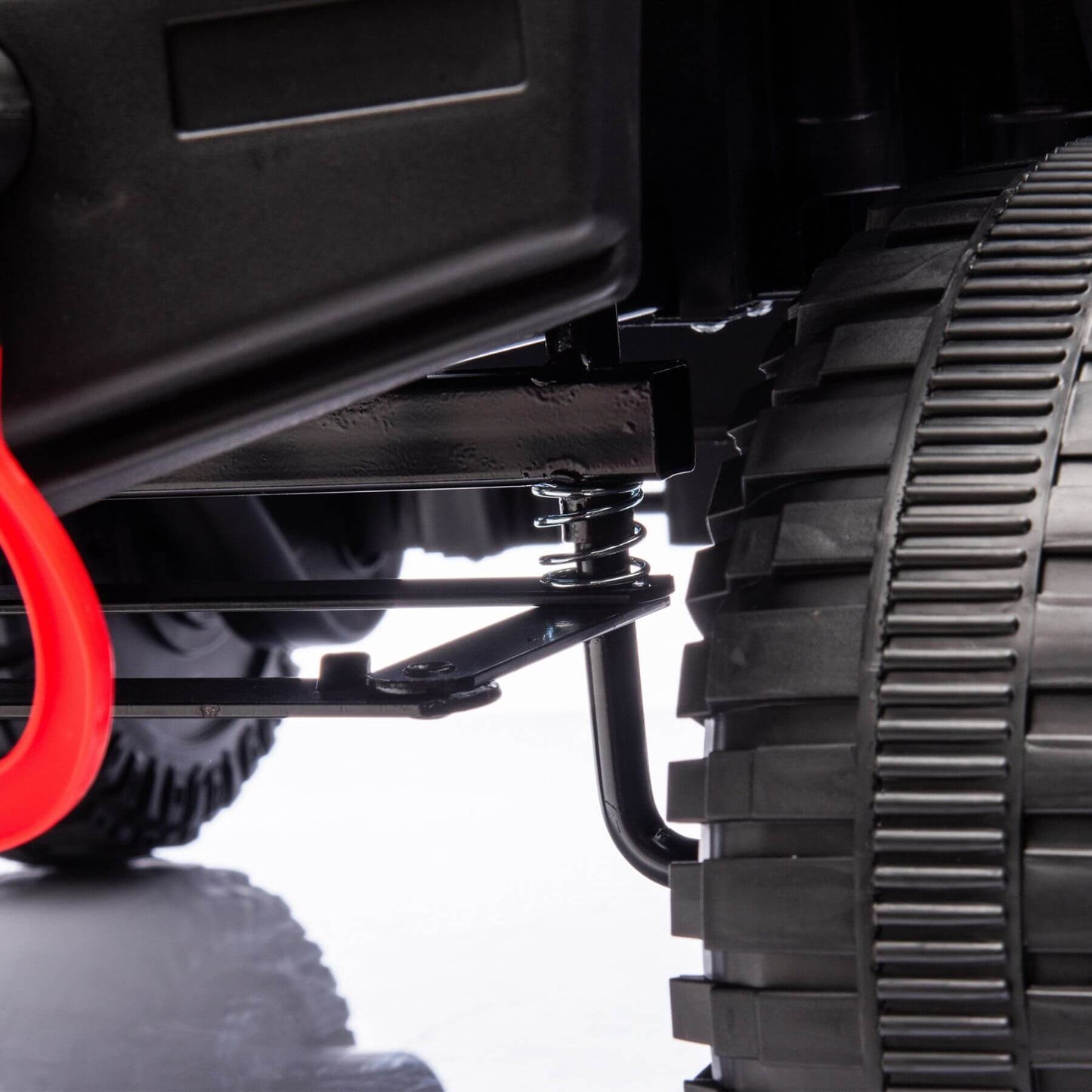 Close-up of a vehicle's suspension system with a black tire and red wheel well on a white background.