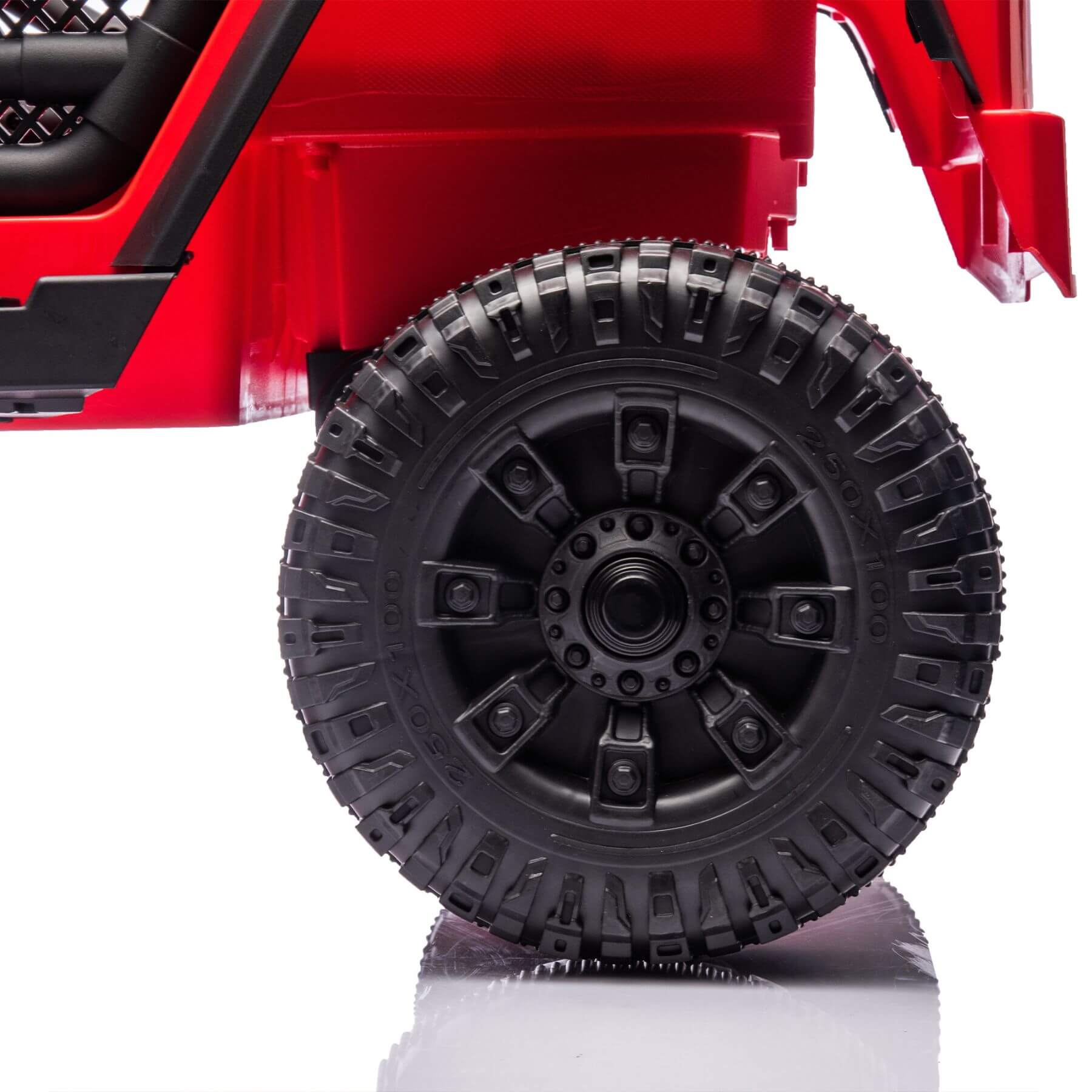 Close-up of a red toy truck with a black tire on a white background