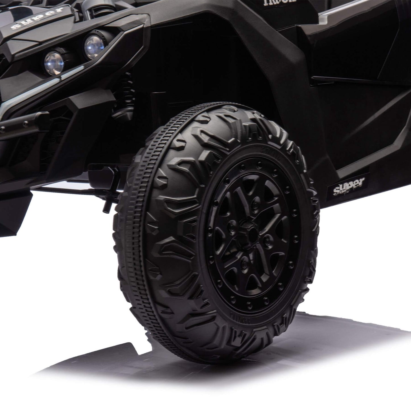 Close-up of a black off-road vehicle tire with tread pattern on a white background