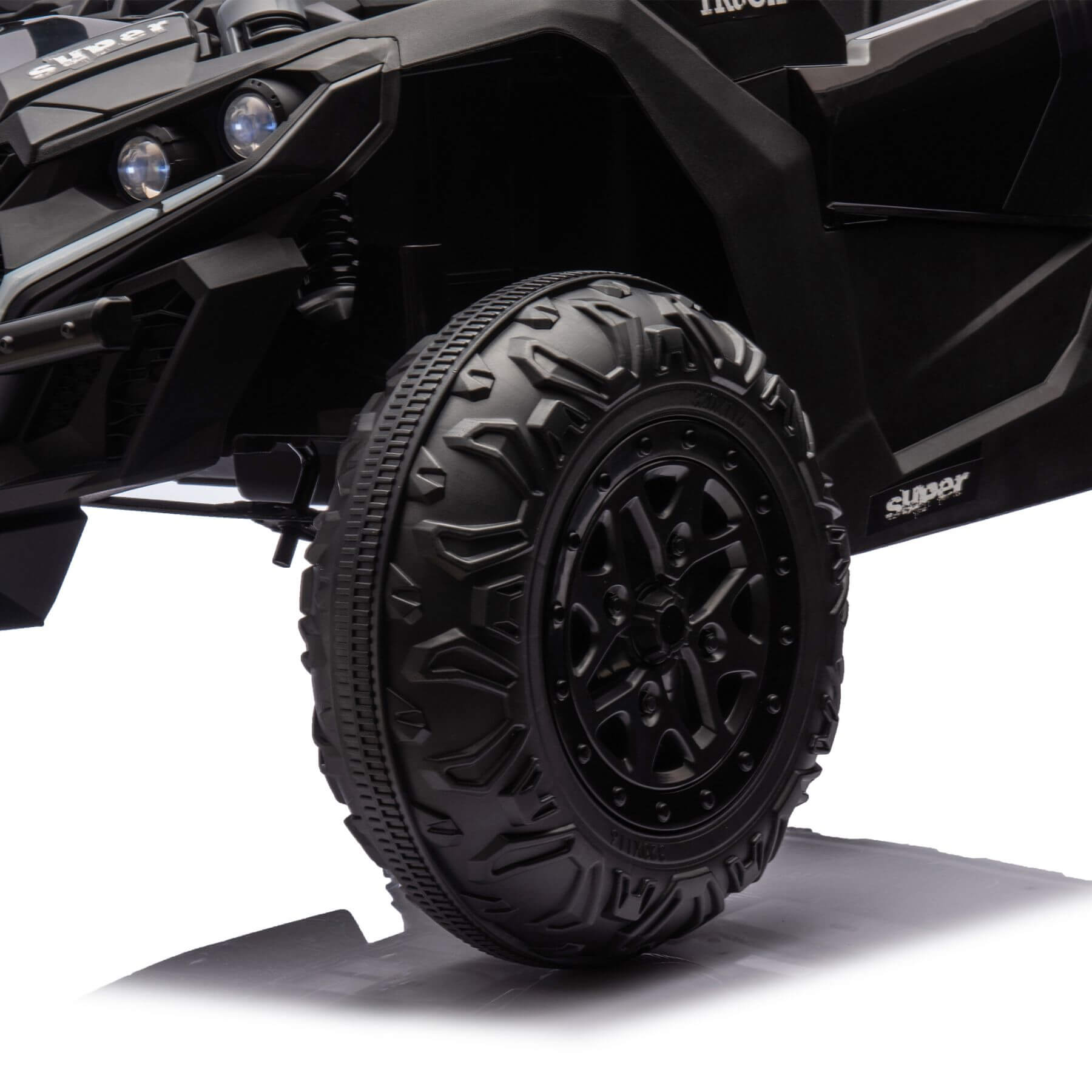 Close-up of a black off-road vehicle tire with tread pattern on a white background