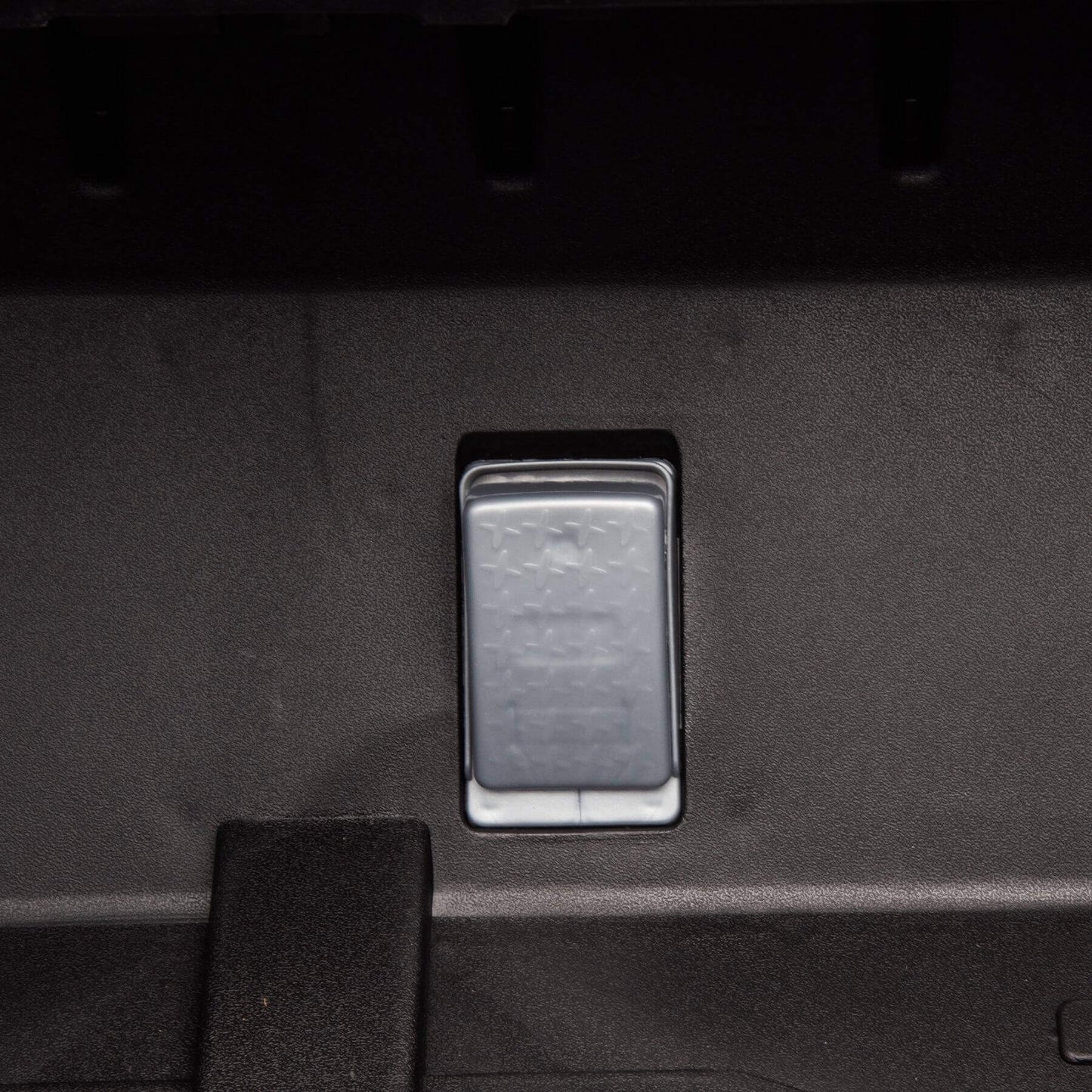 Metallic switch or button on a dark textured surface