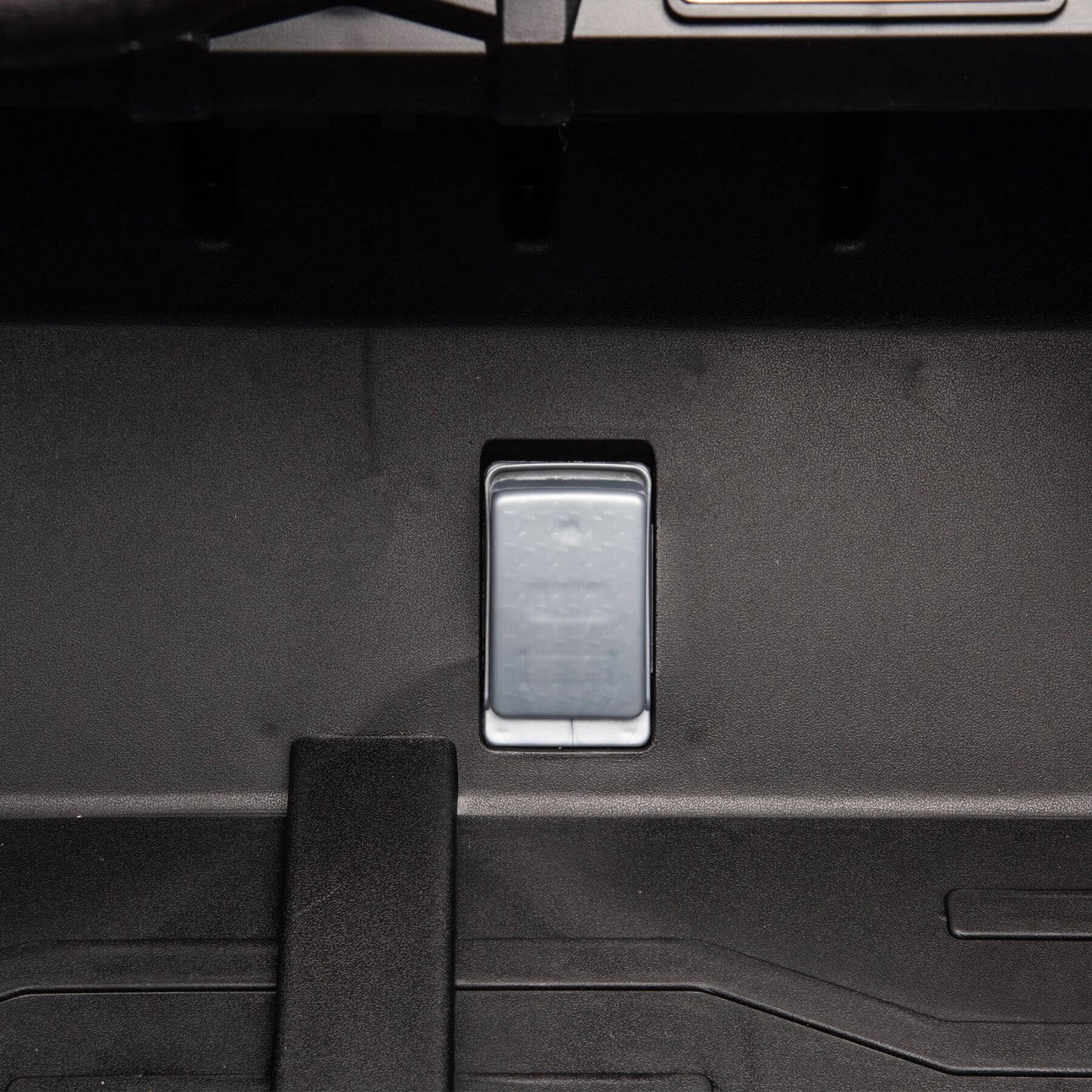 Close-up of a car's open trunk with a footrest inside