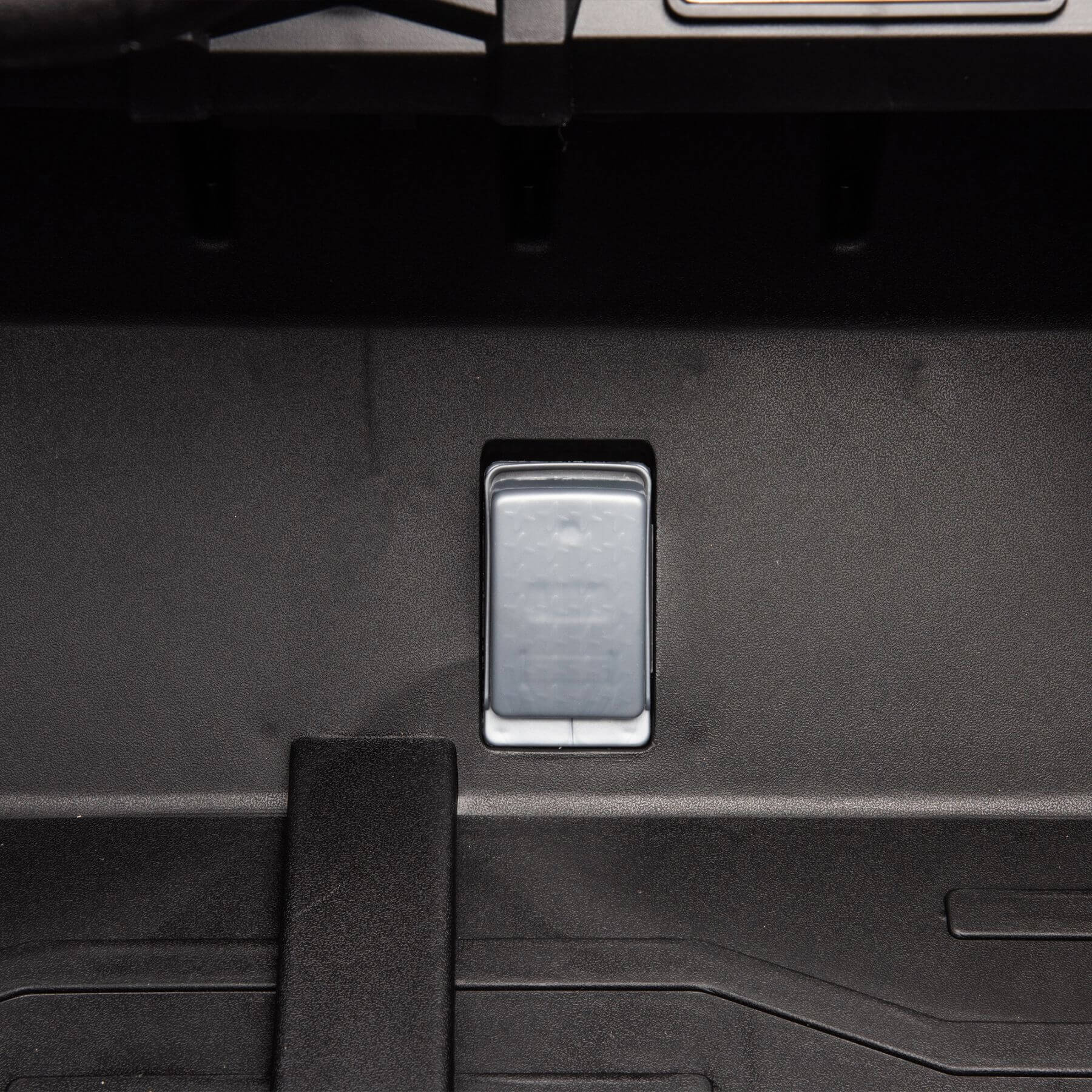 Close-up of a car's open trunk with a footrest inside