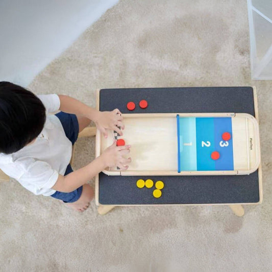 Boy Playing PlanToys 2-In-1 Shuffleboard Game