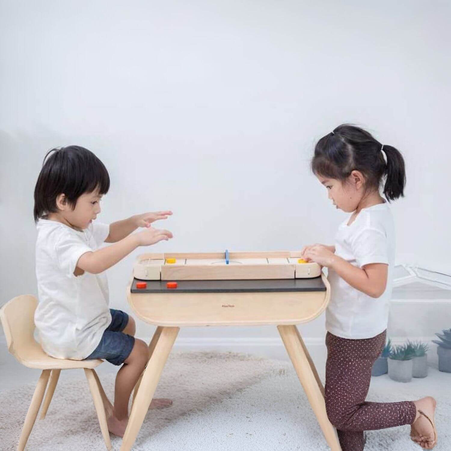 Kids Playing PlanToys 2-In-1 Shuffleboard Game