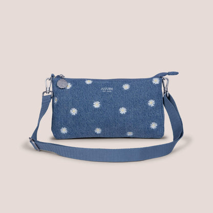 Blue denim handbag with white floral patterns on a beige background