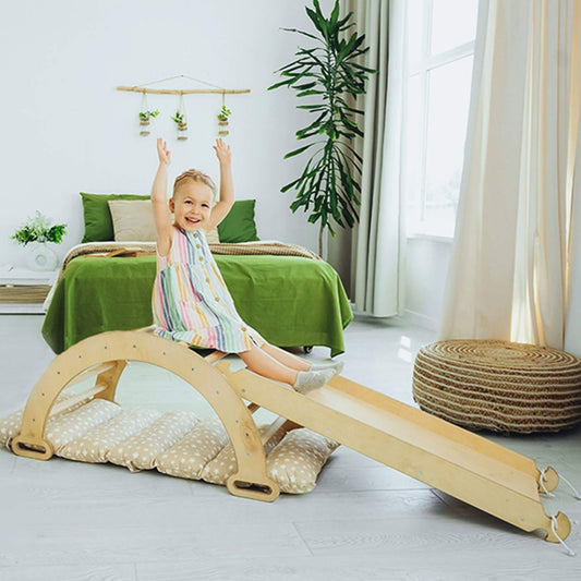 Child playing on Goodevas 3in1 Montessori Climbing Set Beige in a bright room with green bedding and plants.