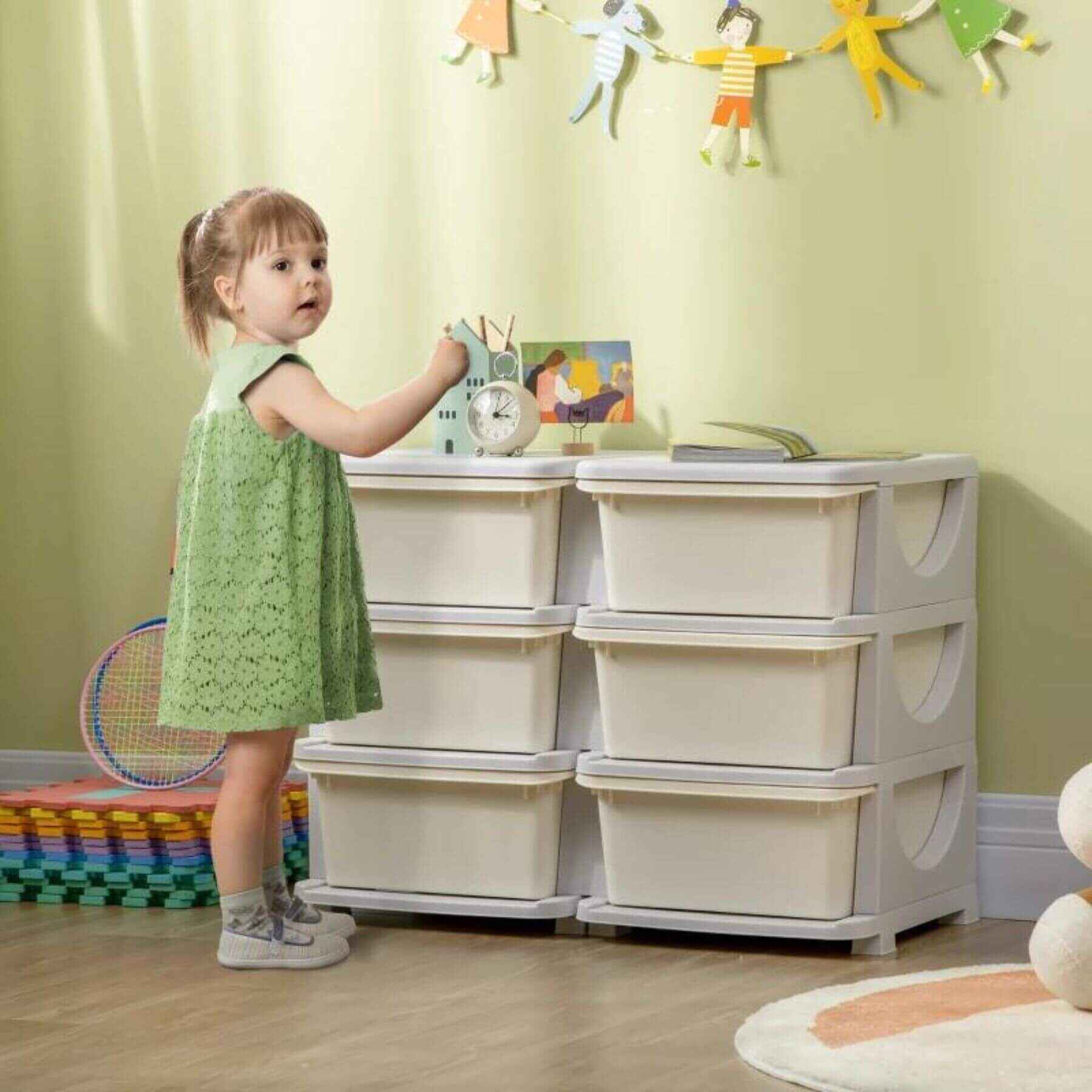 Qaba 3 Tier Kids Storage Unit, 6 Drawer Chest, Plastic Bins for Kids Bedroom Cream White w/ a Girl Standing Next to it