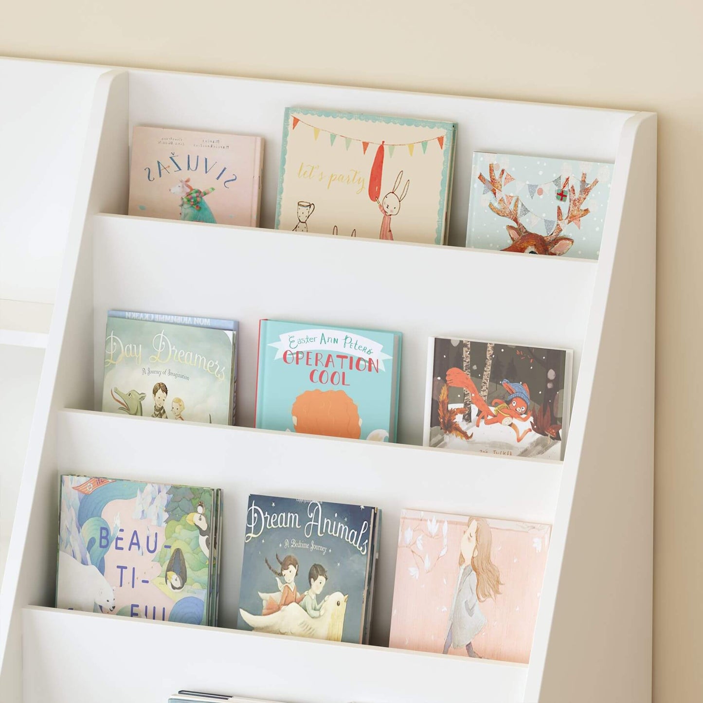 Children's books on a white bookshelf against a beige wall