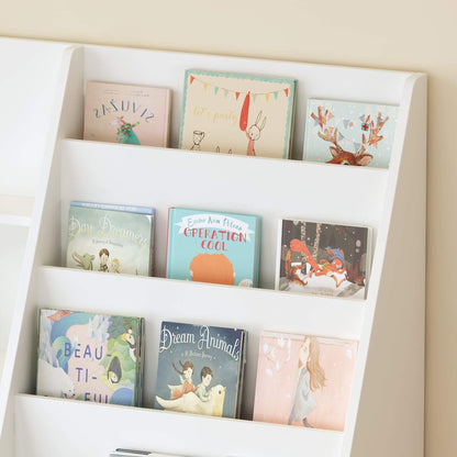Children's books on a white bookshelf against a beige wall